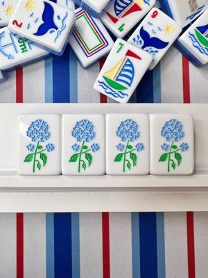 Set of decorative tiles with floral designs on a striped fabric background