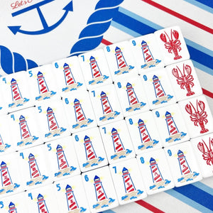 Set of playing cards with lighthouse and lobster designs on a colorful background