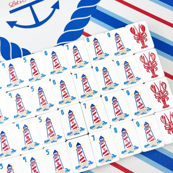 Set of playing cards with lighthouse and lobster designs on a colorful background