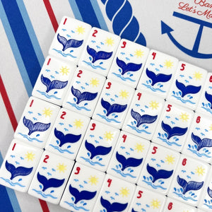 Set of tiles with whale designs and numbers on a striped background