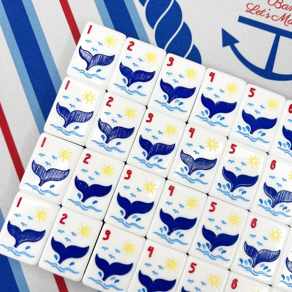 Set of tiles with whale designs and numbers on a striped background